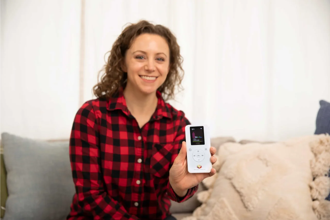 Someone Holding the VIBE Person holding the VIBE PEMF therapy device for natural pain relief and vagus nerve stimulation