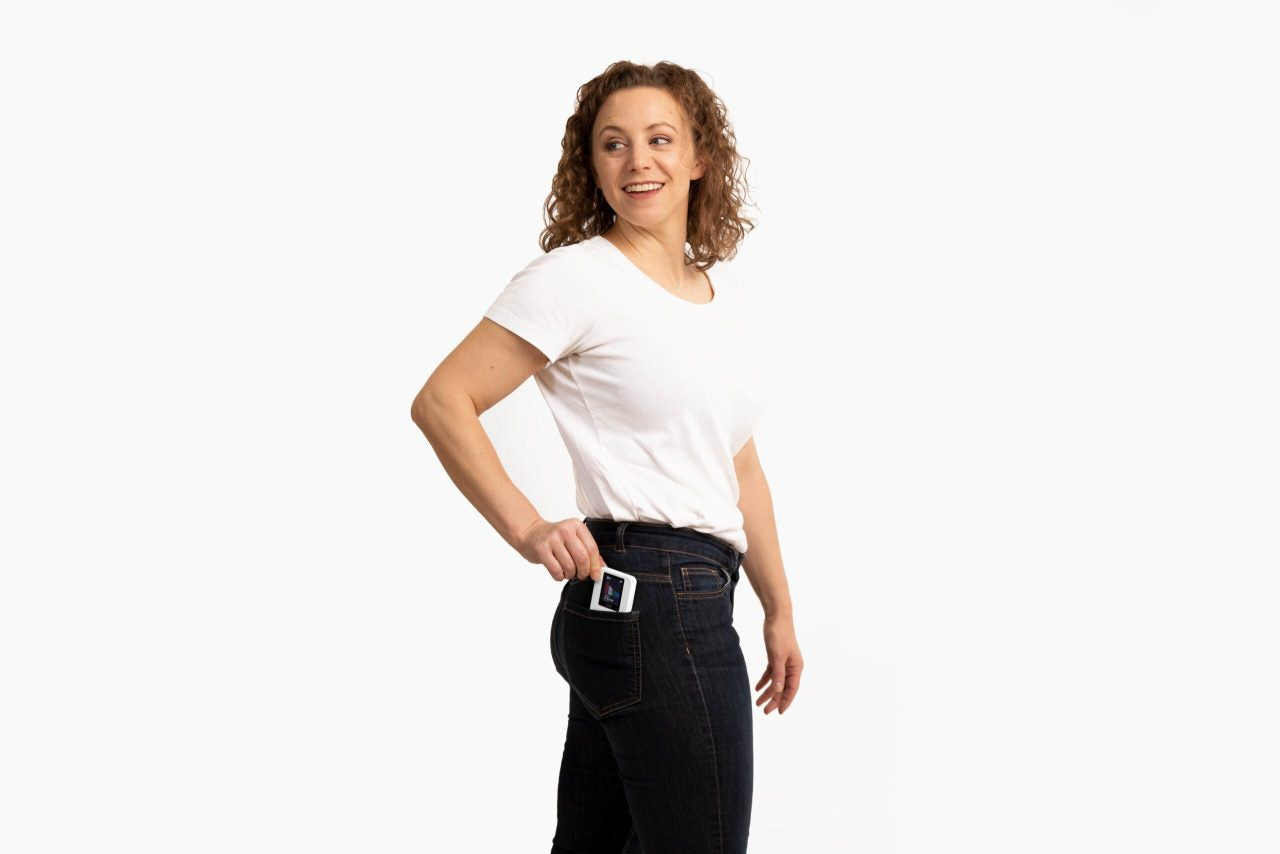 Woman with VIBE in Back Pocket Woman carrying the VIBE PEMF device in her back pocket for on-the-go natural wellness and vagus nerve support